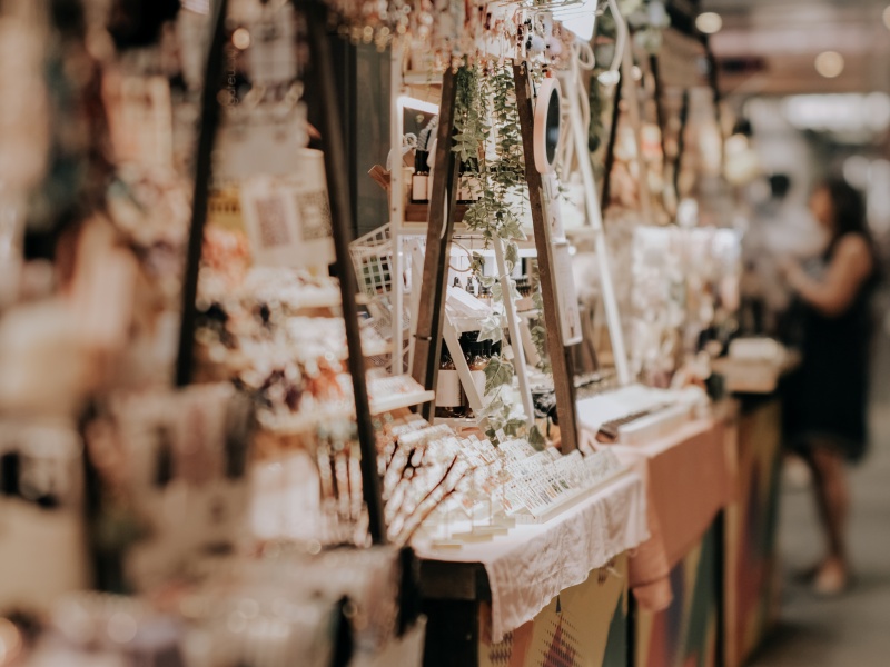 A shopper seen in the distance at an indoor Whistler market, filled with handmade, artisan goods and natural decor.